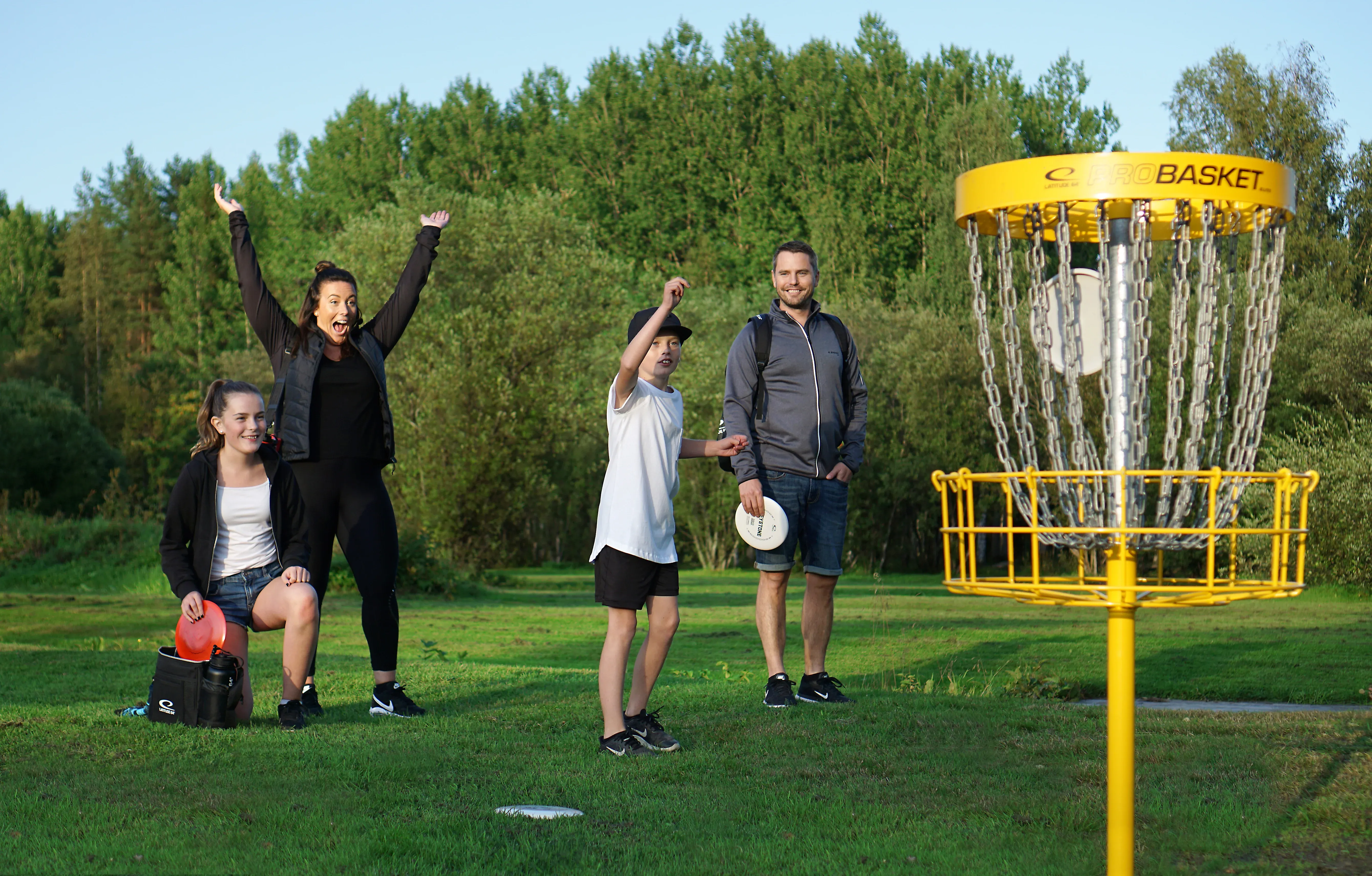 a family tries disc golf